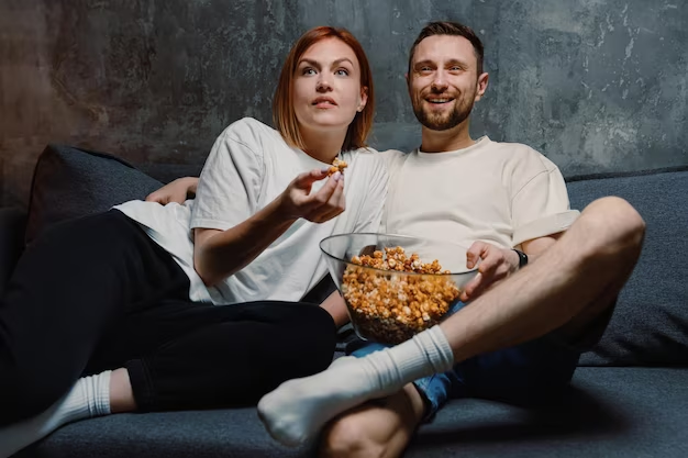 A man and a girl eating popcorn