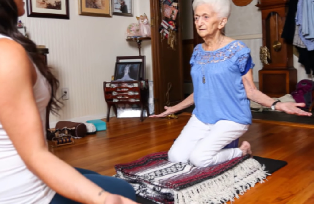 An indoor yoga session unfolds on an ornate rug over a mat